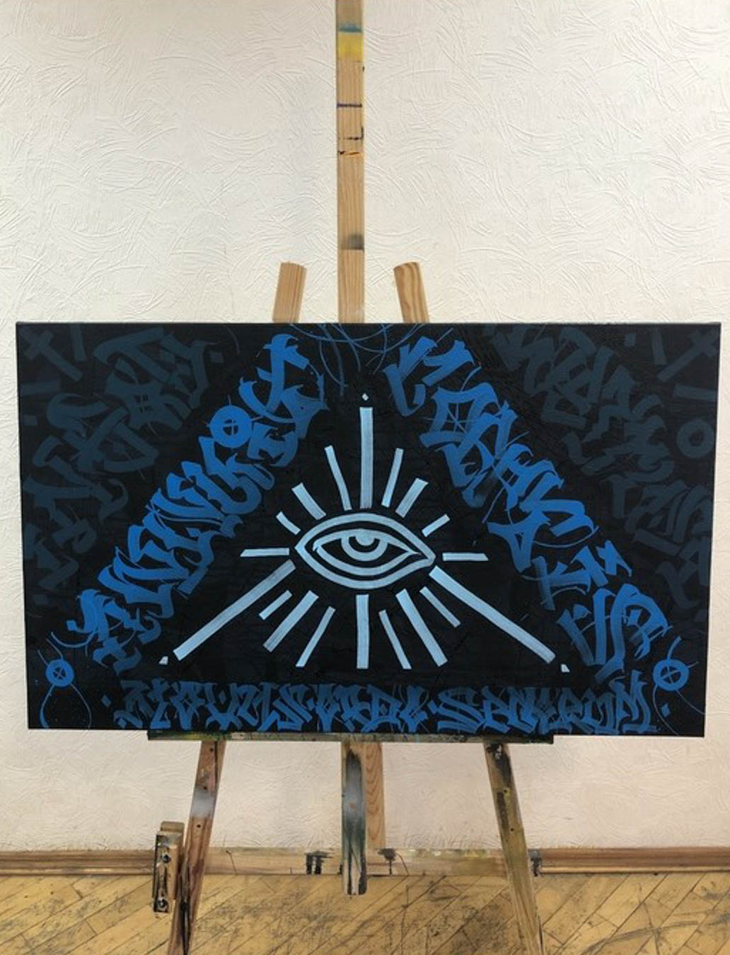 Print of eye surrounded by pyramid shape made of symbols.