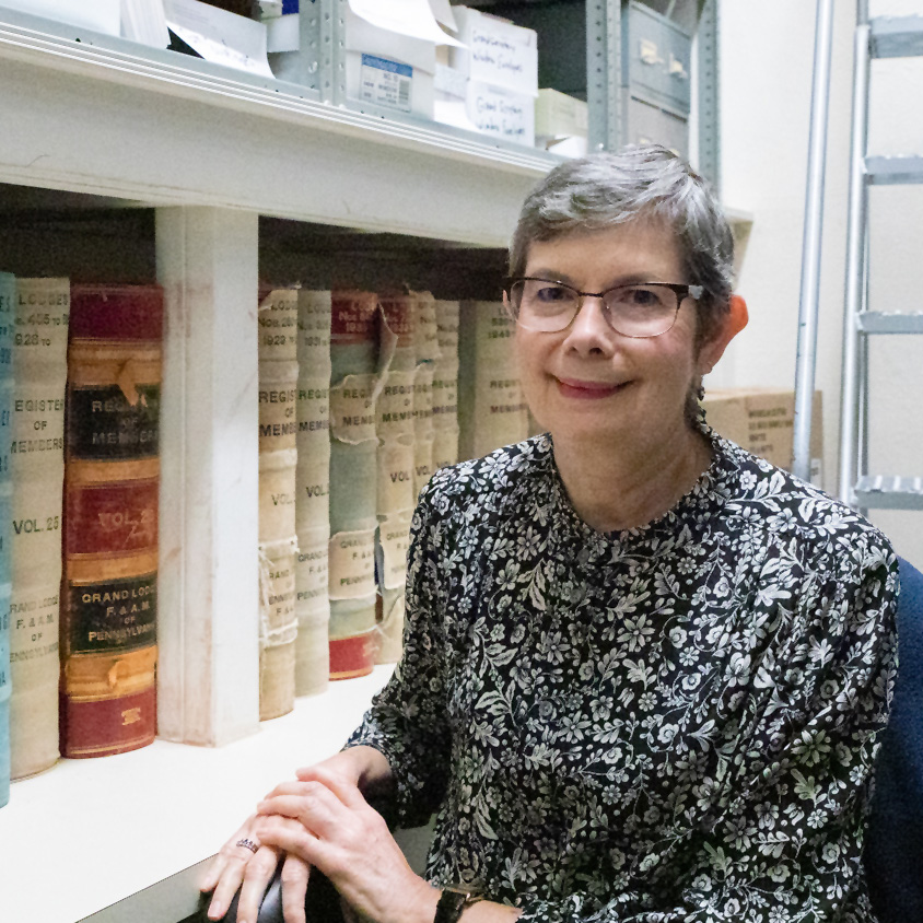 Librarian posing next to books